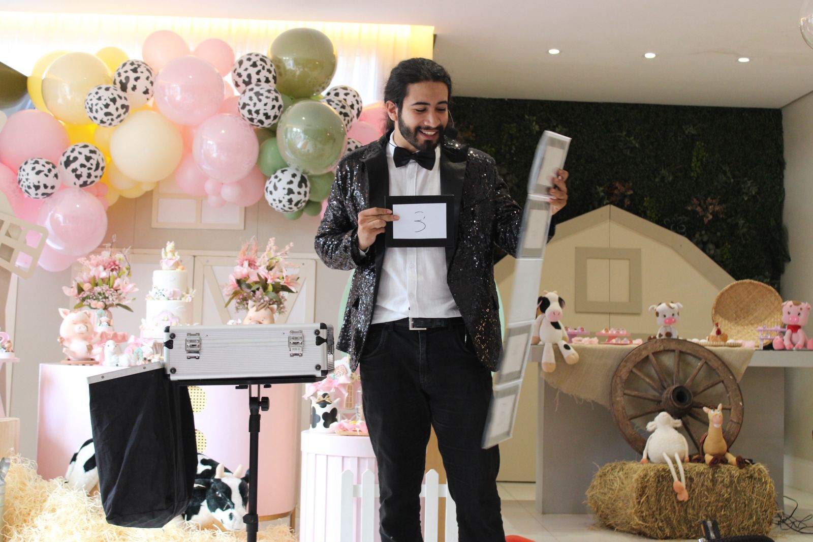 Mágico realizando um número diante da decoração de uma festa